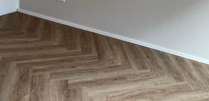 Ausschnitt des Randbereichs, wo der Designboden auf die weiße Wand trifft
